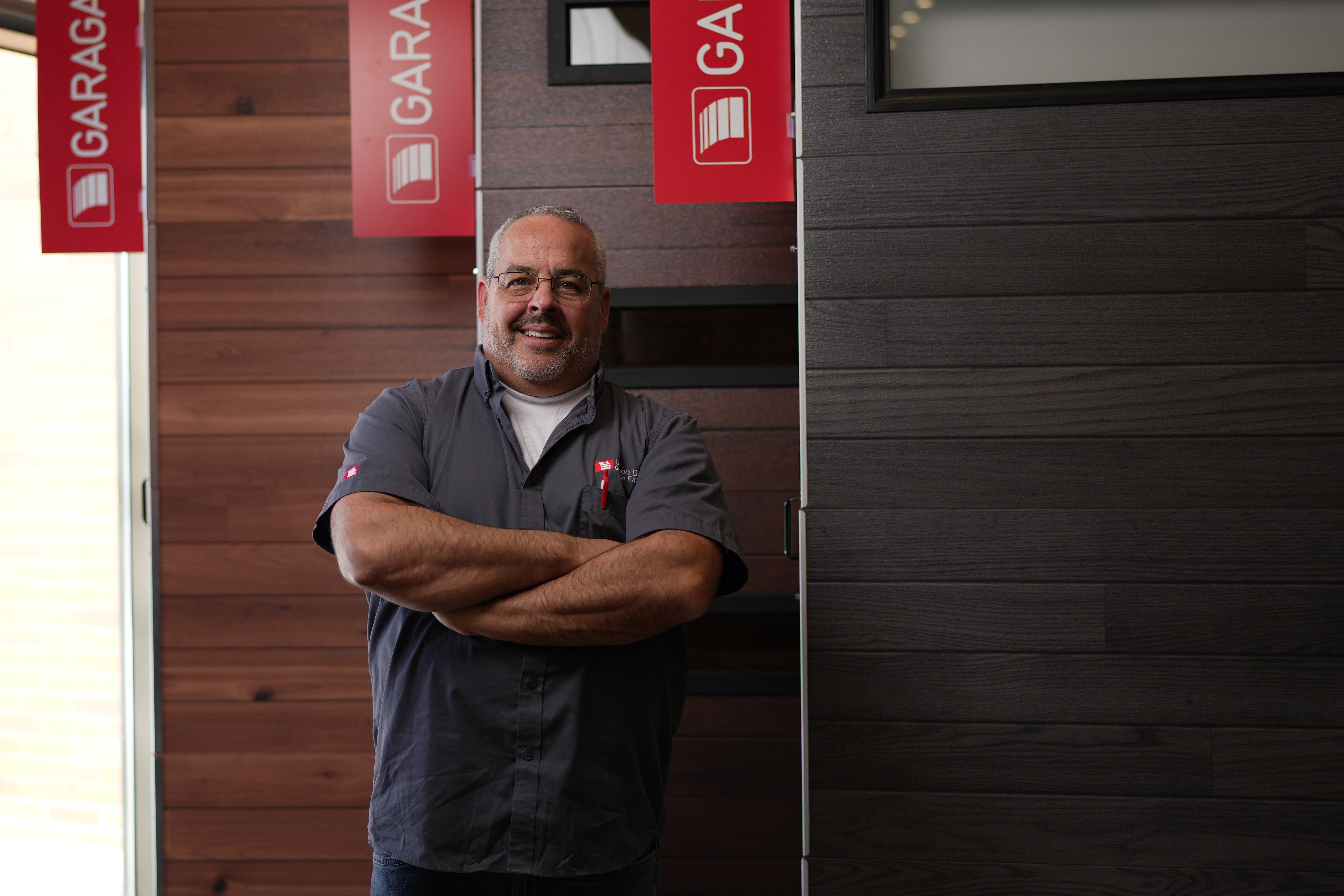 A Gagnon Garage Doors Moncton certified garage door installer and repairman in front of a garage door, sold and installed by Gagnon Garage Doors Moncton in Moncton.
