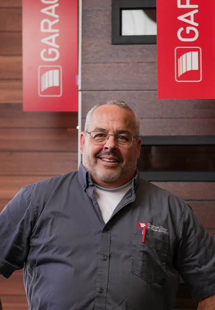Technicien chez Gagnon Garage Doors Moncton devant une porte de garage